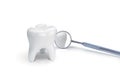 Tooth with dental mirror on white background.