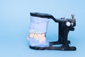 Tooth recovery with implant. Veneers and crowns on gypsum dental artificial jaw on blue background. Upper and lower jaws