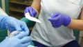 Tooth treatment. Closeup shot of female dentist assistant in gloves opening package with sterile mouth expander
