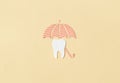 Tooth under an umbrella on a yellow background. Dentist concept. Dentistry and. Dental Health Concept Royalty Free Stock Photo