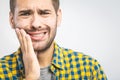 Toothache. Handsome young man suffering from toothache, closeup, touching his cheek to stop pain against white background