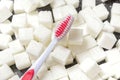 Toothbrush on the background of the sugar cubes of refined sugar, preventing tooth decay, caring for the health of your teeth Royalty Free Stock Photo