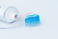 Toothbrush of clear plastic with blue bristles, white blue red toothpaste squeezes out of a tube Royalty Free Stock Photo