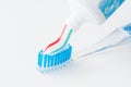 Toothbrush of clear plastic with blue bristles, white blue red toothpaste squeezes out of a tube Royalty Free Stock Photo