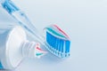 Toothbrush of clear plastic with blue bristles, white blue red toothpaste squeezes out of a tube Royalty Free Stock Photo