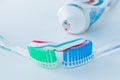 Toothbrush of clear plastic with blue bristles, white blue red toothpaste squeezes out of a tube Royalty Free Stock Photo