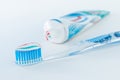 Toothbrush of clear plastic with blue bristles, white blue red toothpaste squeezes out of a tube Royalty Free Stock Photo