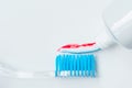 Toothbrush of clear plastic with blue bristles, white blue red toothpaste squeezes out of a tube Royalty Free Stock Photo