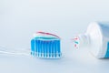 Toothbrush of clear plastic with blue bristles, white blue red toothpaste squeezes out of a tube Royalty Free Stock Photo