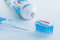 Toothbrush of clear plastic with blue bristles, white blue red toothpaste squeezes out of a tube Royalty Free Stock Photo