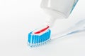 Toothbrush of clear plastic with blue bristles, white blue red toothpaste squeezes out of a tube Royalty Free Stock Photo