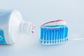 Toothbrush of clear plastic with blue bristles, white blue red toothpaste squeezes out of a tube Royalty Free Stock Photo