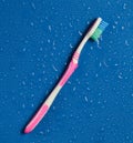 A toothbrush in drops of water on a blue background. Royalty Free Stock Photo