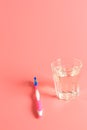 Toothbrush and a glass of water on a pink background Royalty Free Stock Photo