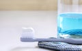 Toothbrush, mouthwash, and cloth on the white table.