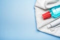 Toothbrush with paste tube, terry towel and mouthwash bottle on blue background. Top view, copy space Royalty Free Stock Photo