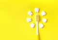 Toothbrush with teeth models making sun on a yellow background. Royalty Free Stock Photo