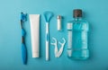 Toothbrush, tongue cleaner, floss, toothpaste tube and mouthwash on blue background with copy space. Royalty Free Stock Photo