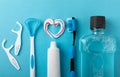 Toothbrush, tongue cleaner, floss, toothpaste tube and mouthwash on blue background with copy space Royalty Free Stock Photo