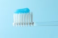 Toothbrush with toothpaste in air on light blue background, closeup Royalty Free Stock Photo