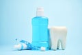 A toothbrush with toothpaste and mouthwash on blue background Royalty Free Stock Photo