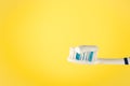 Toothbrush with toothpaste on a yellow background, close up Royalty Free Stock Photo