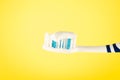 Toothbrush with toothpaste on a yellow background, close up Royalty Free Stock Photo