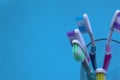 Five toothbrushes stand in a glass beaker on a blue background Royalty Free Stock Photo