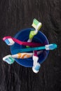 Toothbrushes in a blue plastic glass on black stone background Royalty Free Stock Photo