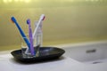 Toothbrushes in blue ,white,purple color in glass cup on blur toothpaste and wash basin background with copy space for dental Royalty Free Stock Photo