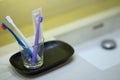 Toothbrushes in blue ,white,purple color in glass cup on blur toothpaste and wash basin background with copy text space for dental Royalty Free Stock Photo