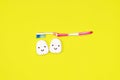 Toothbrushes and dental floss on yellow background