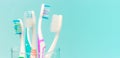 Toothbrushes in glass cup on blue background close-up, copy space Royalty Free Stock Photo