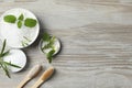 Toothbrushes, green herbs and other teeth care products on wooden table, flat lay. Space for text