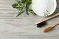 Toothbrushes, green herbs and sea salt on wooden table, flat lay. Space for text