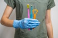 Toothbrushes and Interdental Toothbrushes in dentists hand in rubber gloves.