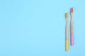 Toothbrushes made of bamboo on light blue background, flat lay. Space for text