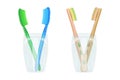 Toothbrushes in mug isolated on white background. Two glass cup with plastic and bamboo toothbrushes. Royalty Free Stock Photo