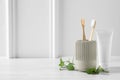 Toothbrushes, toothpaste and herbs on white wooden table. Space for text Royalty Free Stock Photo