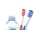 Toothbrushes in water glass with cosmetics bottle Royalty Free Stock Photo