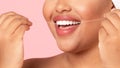 Toothcare and oral treatment concept. Closeup cropped view of unrecognizable black obese woman using dental floss Royalty Free Stock Photo