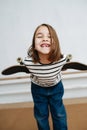 Toothless little girl posing with skateboard, playing cute, leaning forward