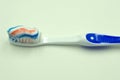 Toothpaste squeezed on the toothbrush on blue background . Royalty Free Stock Photo