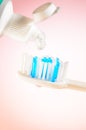 Toothpaste squeezed from tube onto brush on a pink background, close up Royalty Free Stock Photo