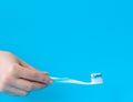 Toothpaste on a toothbrush close-up on a blue light background Royalty Free Stock Photo