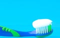Toothpaste on a toothbrush close-up on a blue light background Royalty Free Stock Photo