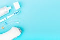 Toothpaste, toothbrush and dental irrigator on blue background with copy space