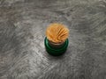 Toothpicks arranged in green circle containers with a textured cement background Royalty Free Stock Photo