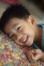 Toothy smiling face of asian toddler lying on floor Royalty Free Stock Photo