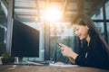 Toothy smiling face of asian younger woman reading message on smart phone screen